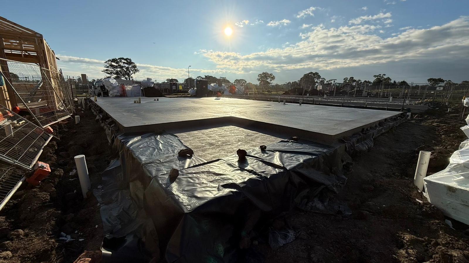 A house slab being finished on a building site at sunset